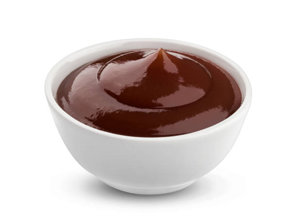 A bowl of rich, dark brown barbecue sauce with a glossy texture, freshly poured and ready for grilling